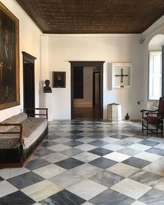 a large room with checkered floors and paintings on the walls