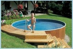 a young boy standing in the middle of an above ground pool