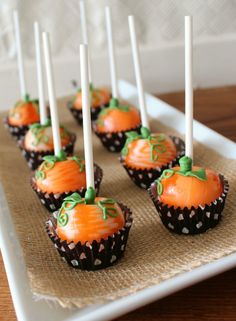 halloween cupcakes with orange frosting and green sprinkles on a white plate