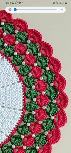 a crocheted doily with red and green flowers