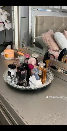 a mirror sitting on top of a dresser next to a tray filled with shoes and other items