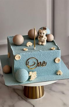 there is a cake that has an animal on it and the word one written in gold