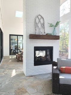 a living room filled with furniture and a fire place in the middle of an open floor plan