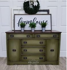 a green dresser with two potted plants and a sign that says farmhouse on it