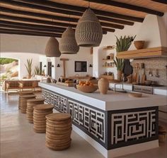 an open kitchen with lots of counter space and wicker baskets hanging from the ceiling