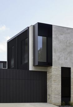 an exterior view of a modern house with black shutters and white brickwork on the walls