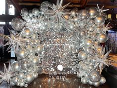 an image of a christmas decoration with silver balls and snowflakes on display in front of a mirror wall