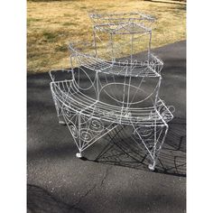 three metal baskets sitting on top of each other in the middle of a park area