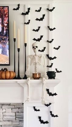 a fireplace decorated for halloween with bats and candles