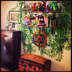 there is a wall with plants growing on it and shelves filled with figurines