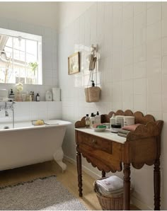 a white bath tub sitting next to a wooden table