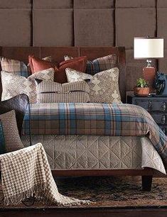 a bed with plaid sheets and pillows in a room