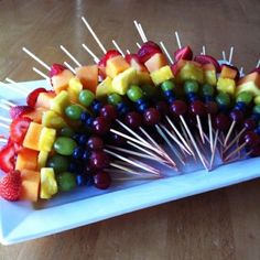 a platter filled with fruit and skewers