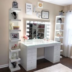 a white vanity with lights on it in front of a mirror and shelves filled with shoes