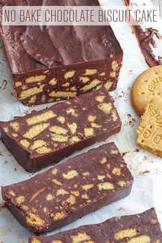 chocolate and peanut butter fudge bars on parchment paper next to two cookies, one cut in half