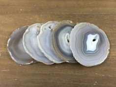 five agate shell pieces sitting on top of a wooden table