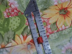 a pair of scissors sitting on top of a piece of fabric next to a ruler