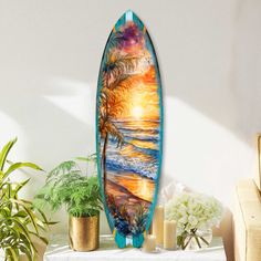 a surfboard sitting on top of a table next to potted plants and candles