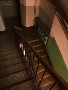 the stairs are made of wood and have metal railings on each side, along with green painted walls