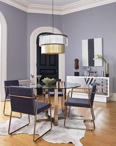 a dining room table with chairs and a chandelier hanging from it's ceiling