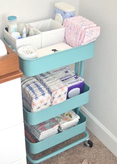 a blue shelf filled with lots of diapers next to a bathroom sink and toilet