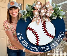 a woman holding up a baseball themed sign