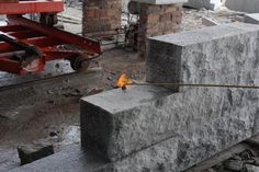 a piece of metal sitting on top of a cement block next to a pile of rubble