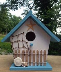 a birdhouse with a fence and starfish on it