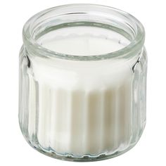 a glass jar filled with a white candle