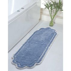 a blue bath mat sitting on top of a bathroom floor next to a white tub