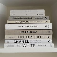 a stack of books sitting on top of a white shelf