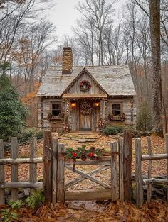 an old log cabin with wreaths and lights on the front door is surrounded by leaves