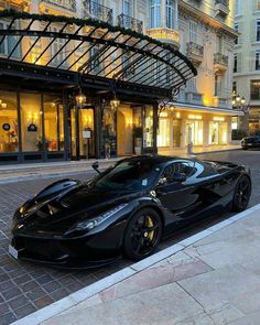 a black sports car parked in front of a hotel