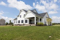 a large white house sitting on top of a lush green field