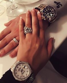 a woman's hands with three different rings on her wrist and two other watches