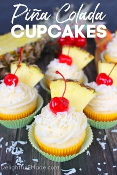 pineapple cupcakes with white frosting and cherries are on a table