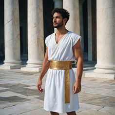 a man dressed in white and gold standing next to some pillars with columns behind him