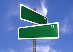 two green street signs pointing in opposite directions against a blue sky with wispy clouds