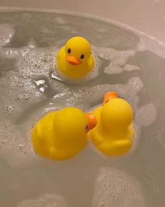 three rubber ducks in a bathtub with bubbles