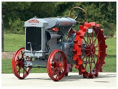 an old fashioned tractor is parked on the sidewalk