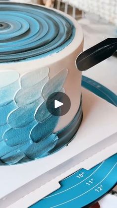 a video demonstrating how to decorate a cake with blue icing and white frosting