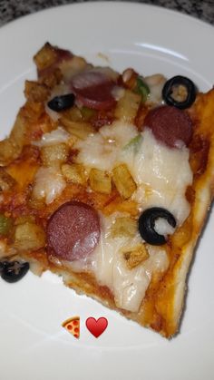 a slice of pizza on a plate with olives, pepperoni and other toppings