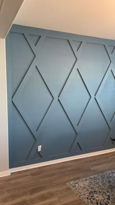 an empty room with blue walls and wood floors