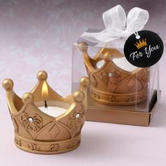 a gold crown shaped candle holder with a ribbon tied around it and a gift tag attached to the top