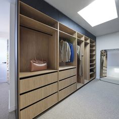 an empty walk in closet with clothes and handbags