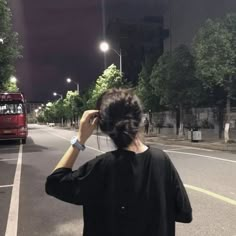 a woman standing on the side of a road at night