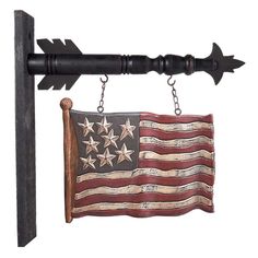 an american flag hanging on a black metal pole with two wooden poles attached to it