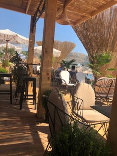 chairs and umbrellas are set up outside on the patio for people to sit down