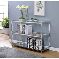 a metal shelf with books and magazines on it in a room next to a window