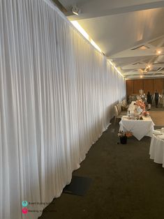 an empty banquet room with white drapes covering the walls